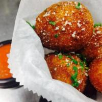 Arancini · Fried rice balls with ham and peas with a side of marinara sauce 