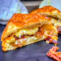 Caramelized Onion and Brie Sandwich · A flaky, house-made croissant bun loaded with crispy bacon, caramelized onions and gooey bri...