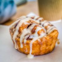 Cinnamon Roll Croissant · A rich brioche dough, layered with butter and cinnamon sugar and topped with frosting and ci...