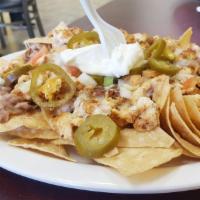 Nachos · Beans, cheese, meat, tomatoes, jalapenos, and sour cream.