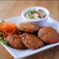 Tod Mun · Deep fried fish cake, blended with curry paste and green beans, served with cucumber salad.