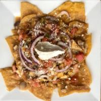 Chilaquiles de Pollo · Chicken. Sauteed with onions, tomatoes and salsa roja. Served over a bed of corn chips, topp...