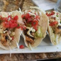 Grilled Mahi Mahi Tacos · Marinated wild caught mahi mahi on corn tortillas with cabbage, cilantro, avocado crema and ...
