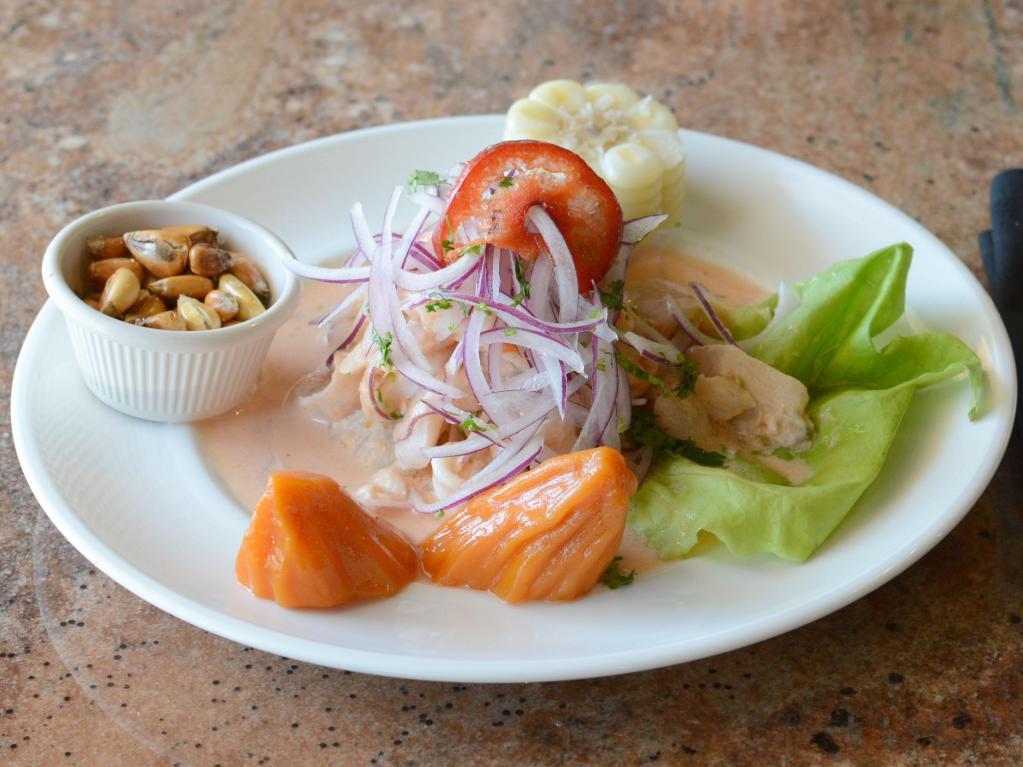 Ceviche de Pescado · Marinated fresh fish in fresh lime juice, mixed with onions, cilantro and a touch of rocoto pepper. Served with potato, Peruvian corn on the cob and dried corn kernel.
