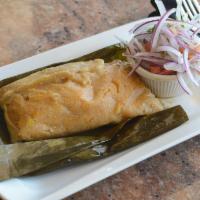 Tamales de Maiz · Tamales made out of corn dough filled with pork, eggs and peanuts wrapped in a plantain leaf...