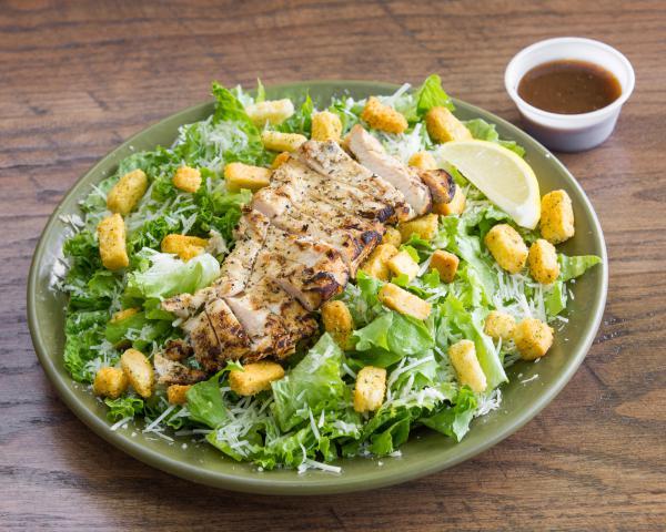 Chicken Caesar Salad · Grilled or crispy chicken, Parmesan, croutons and lemon with Caesar dressing.