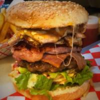 Tripleta Burger · Beef, chicken, smoked pork chop, bacon, ham, cheese, fried egg, avocado, grilled onion, lett...