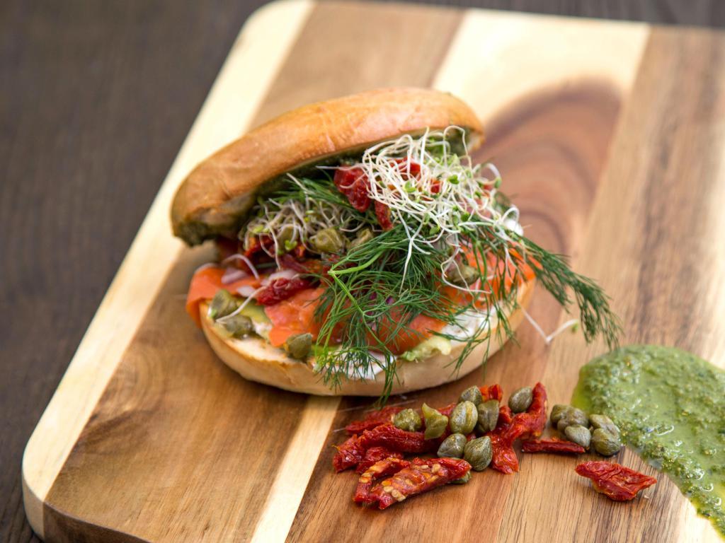 5. The Smokey Lox Sandwich · Smoked salmon, cream cheese, capers, red onions, semi-dried tomatoes, dill, arugula, sprouts and pesto on bagel.