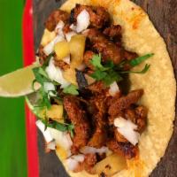 Al Pastor Taco · Handmade tortilla, grilled pineapple, cilantro, onions and salsa verde.