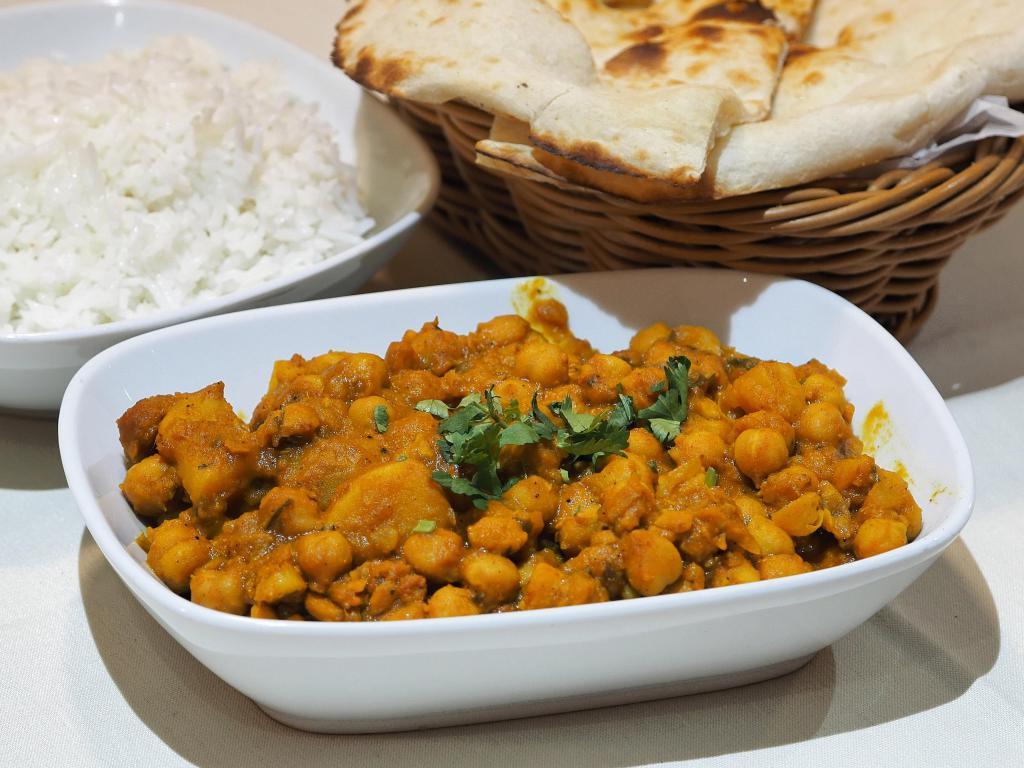 Aloo Chole · Chickpeas slowly simmered and cooked with potatoes, onions, tomatoes and house spices. Gluten free.