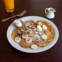Banana Nut Pancakes · 6 buttermilk pancakes filled and topped with fresh bananas and pecans. Dusted with powdered ...