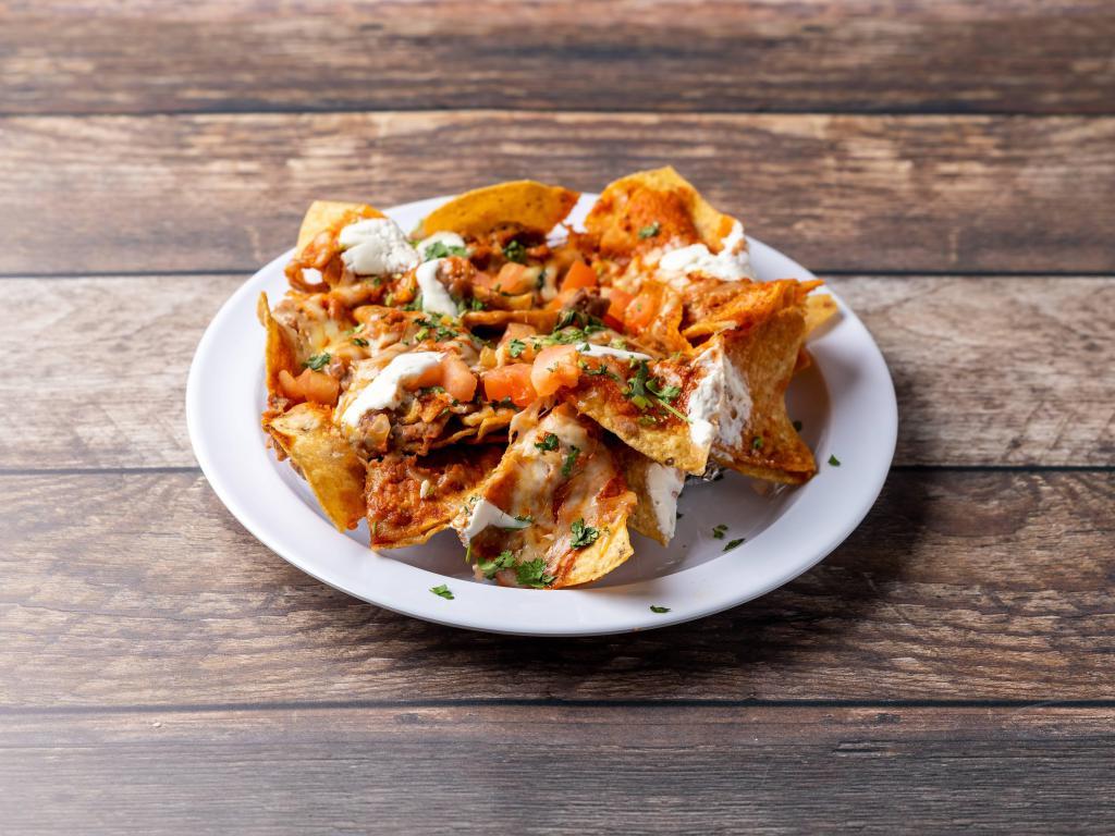 Nachos Grandes · Crispy tortilla chips with beans, ranchero sauce, melted cheese, sour cream and pico de gallo. Side of Guacamole or choice with meat (+5)