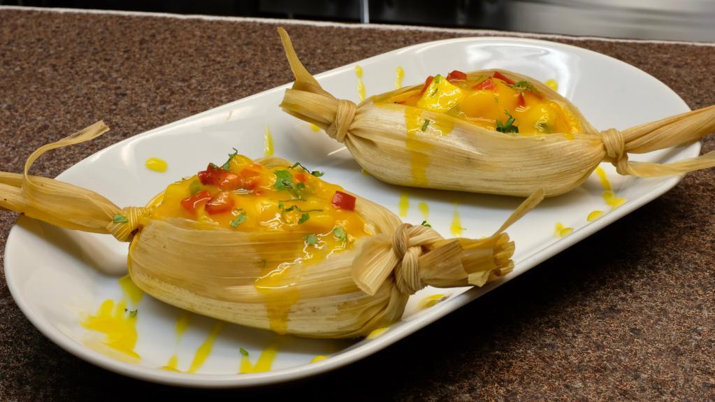 Tamal de Mango · Homemade corn tamales stuffed with cream goat cheese, chile chipotle and covered with fresh pico de mango. Gluten free, lactose allergy, not spicy, nut free, vegetarian.