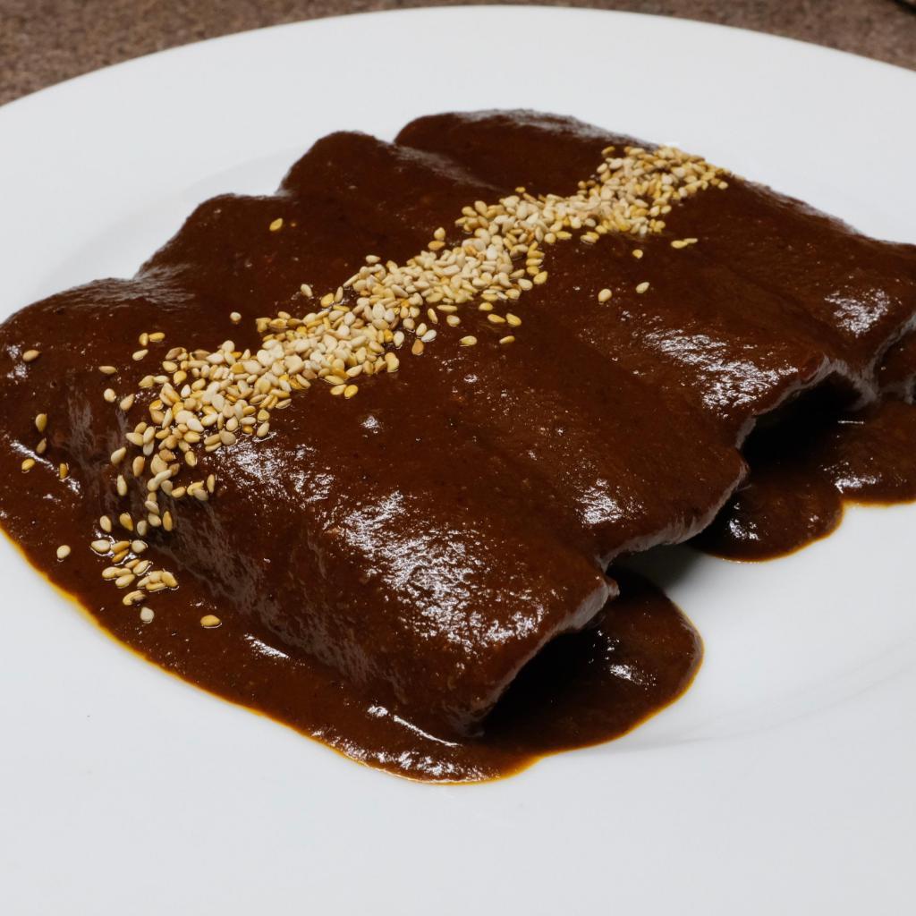 Enchiladas Poblanas · Four corn tortillas covered with Mole Poblano.  Filled with choice of beef, beans, chicken, cheese, guacamole or chorizo.  Served with rice and beans. Not spicy, some moles are gluten free check with kitchen, can be lactose free, shellfish free, not nut free.