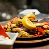 New Rebozo Shrimp Fajitas · Sautéed shrimp cooked with sizzling bell peppers, onions and tomatoes. With side of sour cre...