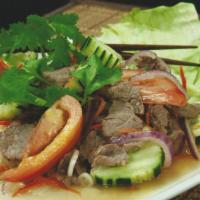 34. Spicy Beef Salad · Grilled tender beef, flavored with lime juice, chilies, onions, carrots, cucumbers and cilan...