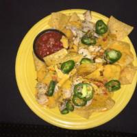 Chicken Nachos · Tortilla chips topped with house made queso, diced grilled chicken breast, jalapeños and com...