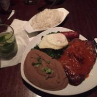 Tutu a Favela · Tender grilled pork chop and Brazilian sausage topped with fried eggs and served with a bean...