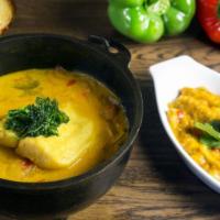 Moqueca de Peixe com Pirao · Fish stew made with palm oil, green herbs, onions, tomatoes and coconut milk served with pin...