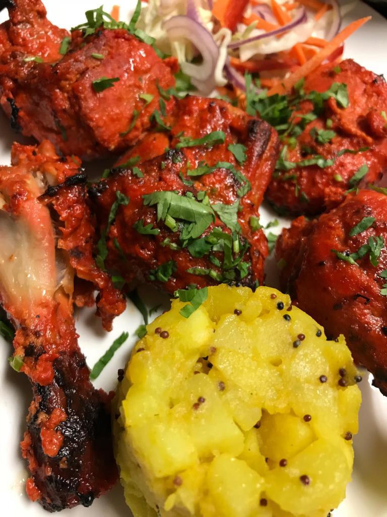 Tandoori Chicken · Chicken marinated in fresh spices and lemon, then barbecued over flaming charcoal in the tandoor. 