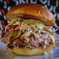 Pulled Pork BBQ Sandwich · Served with pickles, red onions and sauce.