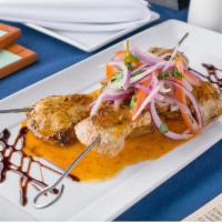 Anticuchos de Pollo · Grilled Chicken skewers marinated in homemade anticuchera sauce, served with potatoes and sa...