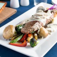 Bistec con Salsa de Champinones y Pastel de choclo · Grilled New York steak bathed in our homemade sauce. Served with sauteed vegetables and Peru...