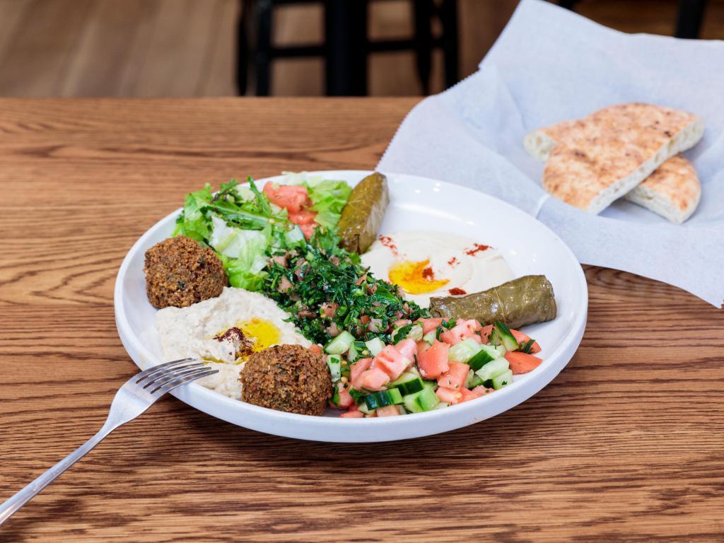Maza Deluxe Platter · falafel , hummus,baba ghanoush, tabbouleh, stuffed grape leaves with a fluffy pita 
