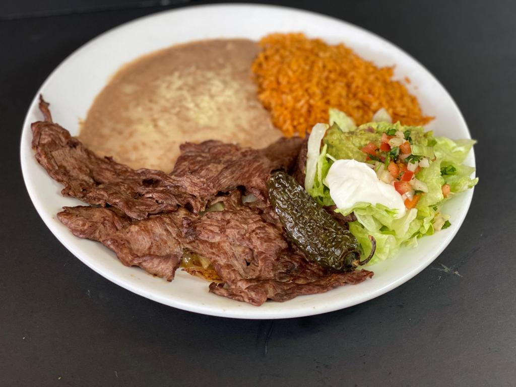 Carne Asada Plate · Thin-sliced beef steak grilled to perfection. Served with grilled onion and pico de gallo. Served with rice, shredded lettuce, tomato, and onion.