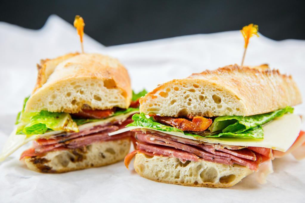 Authentic Italian Sandwich · Sweet sopressata, Genoa salami, capicola and provolone cheese with fresh Roma tomatoes, onion, pickles, black olives and leaf lettuce drizzled with a Tuscan herb vinaigrette served on a baguette. Served with kettle cooked potato chips and a crisp pickle spear.