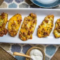 Potato Skins · Yukon Gold Potato tops baked with Cheddar Cheese and Applewood Smoked Bacon. This is a Heat ...