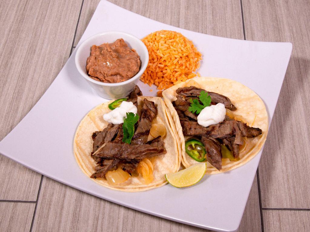 Steak Fajitas · Grilled peppers tomatoes and onions. Served with guacamole, sour cream, grated cheese, rice, and beans tortillas.
