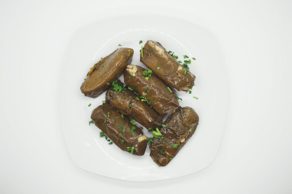Grape Leaves · Dolmades. 6 stuffed grape leaves with rice and olive oil served with a tzatziki dipping sauce.