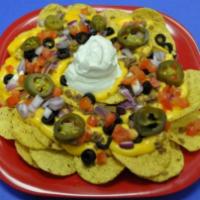 Ultimate Nachos · Home-made corn tortilla nachos topped with cheddar cheese, chili, diced tomatoes, diced red ...