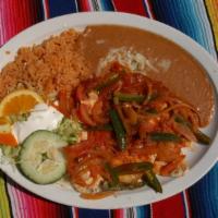 Huevos Rancheros · 2 eggs sunny side up with salsa and a tostada on the bottom with tortillas, refried beans, c...