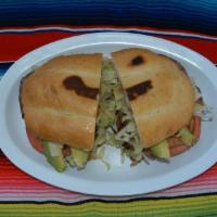 Torta Mexicana · Mexican bread, re-fried beans, cheese, guacamole, sour cream, lettuce, tomato, jalapeno pepp...