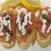 Salmon Toasts · Toasted baguette in olive, topped with smoked salmon, sour cream, dill, lemon and capers.