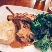 Lamb Bim Bam Boum · Lamb chops cooked with mushrooms, Madeira wine sauce, served with mashed potatoes and greens.