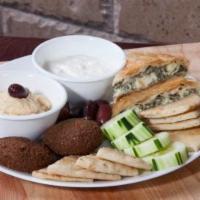 Appetizer Platter · Appetizer sampler with spinach pie, falafel, pita bread, cucumbers, olives, hummus, and tzat...