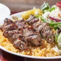Lamb Skewers (Souvlaki) (3) · Three char-grilled lamb skewers over rice with a Greek salad.