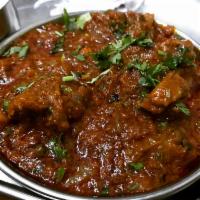 Goat Karahi · Tender meat of goat cooked with onion, bell peppers, tomato, sauce and finished with cilantro.