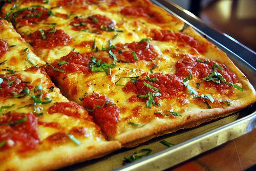 Nona's Specialty Pizza · Mozzarella cheese, tomato sauce, fresh garlic, Pecorino Romano cheese and basil. Thin square pizza cut into 12 slices.
