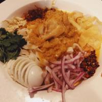 C3. Nan Gyi Thoke · Burmese rice noodles with a mild chicken coconut curry sauce, egg, split yellow peas, fried ...
