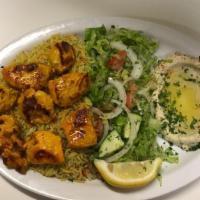 Chicken Kabob Dish · Cubic size of chicken served with hummus, salad, and rice.