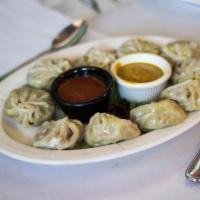 Vegetable Momos appetizer · Steamed mixed vegetable dumplings served 6 pcs with tomato pickle & spice sauce.