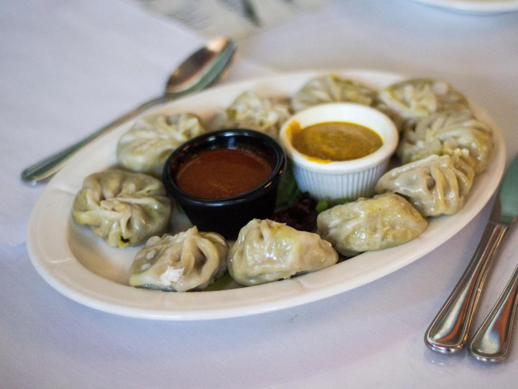 Vegetable Momos appetizer · Steamed mixed vegetable dumplings served 6 pcs with tomato pickle & spice sauce.