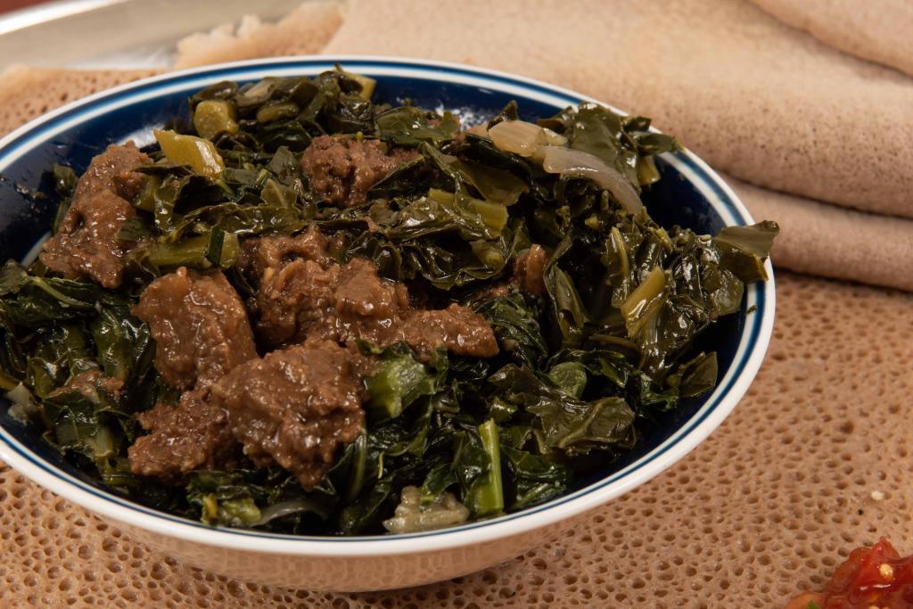18. Gomen Besiga · Chopped collard greens mixed in mild Ethiopian sauce with beef. served on regular injera with side house salad and side spices