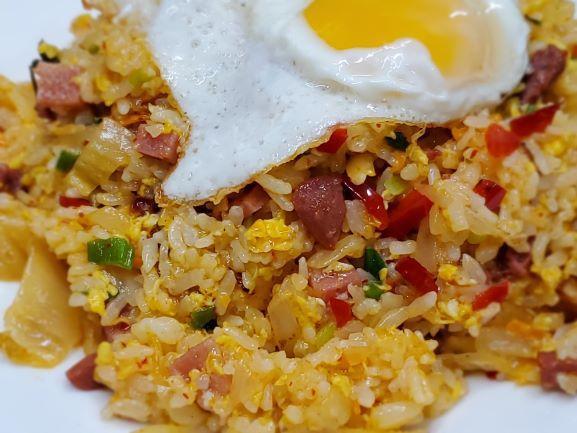 Boo Dae Bokkeum Bap · Stir fried rice with ham, sausage, kimchi and finely diced vegetables, topped with a fried egg. Very popular item.