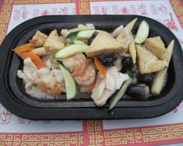 84. Sizzling Seafood Plate · Prawns, scallops, chicken, fried tofu and vegetables served in white wine sauce on a hot plate.