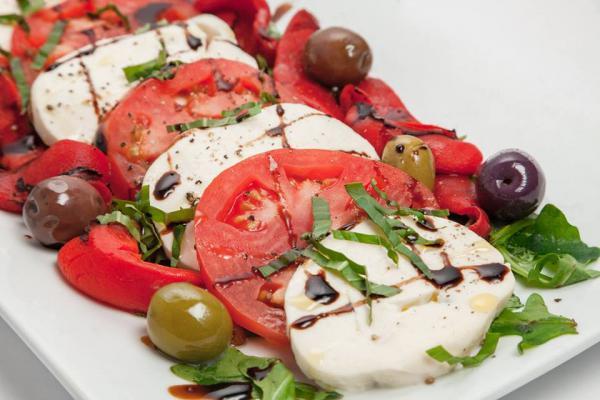 Caprese Fresh Mozzarella · Fresh house-made mozzarella, Roma tomatoes, oven-roasted peppers, fresh basil and Mediterranean olives.